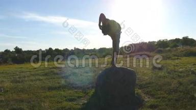 年轻的运动男子站在石头瑜伽姿势户外。 瑜伽在大自然中练习<strong>瑜伽动作</strong>和姿势。 运动员